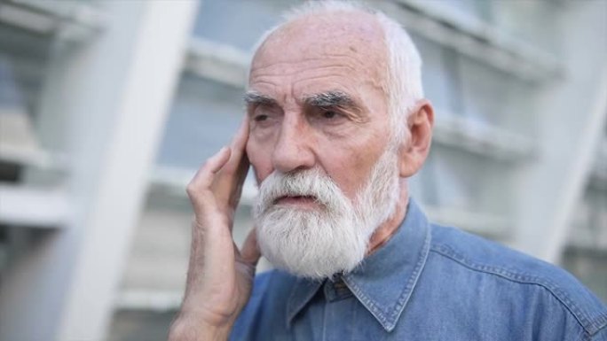头晕的老年男性站在户外，感觉虚弱，低血压，疼痛