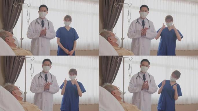 亚洲医生和护士通过微笑拍手鼓励躺在床上的生病老人。在医院大流行期间，患者和医生团队戴着口罩防止新型冠