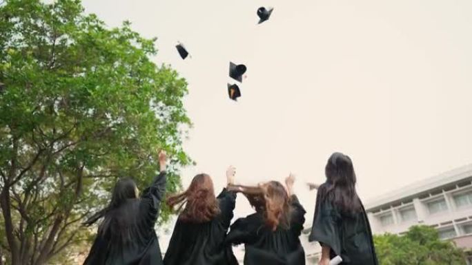 一组毕业的亚洲学生穿着学术礼服和毕业帽持有文凭