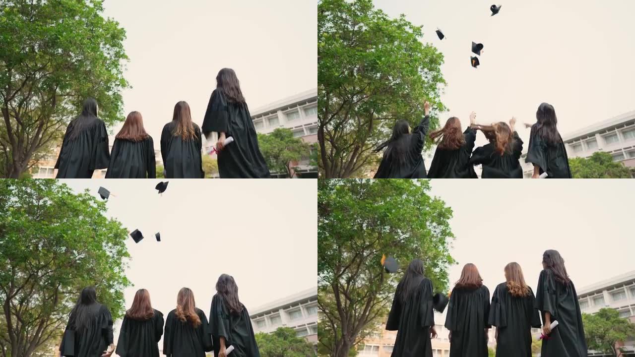 一组毕业的亚洲学生穿着学术礼服和毕业帽持有文凭