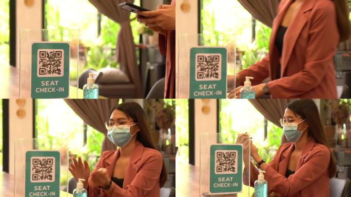 一名戴着外科口罩的亚裔员工在咖啡店里用手机工作