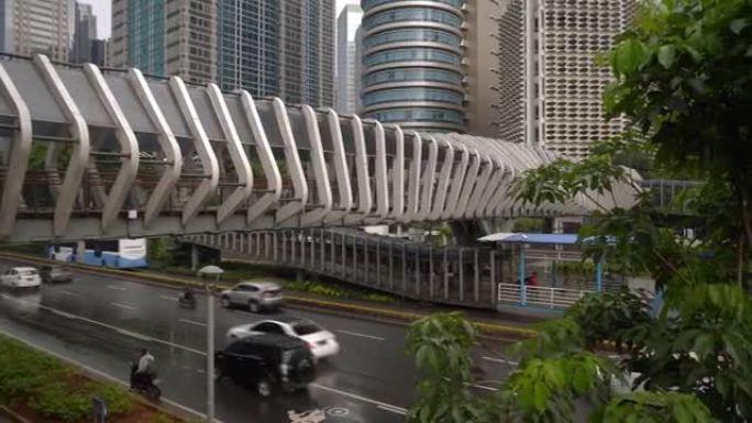 雨天雅加达市市中心著名人行天桥交通街顶部慢动作全景4k印度尼西亚