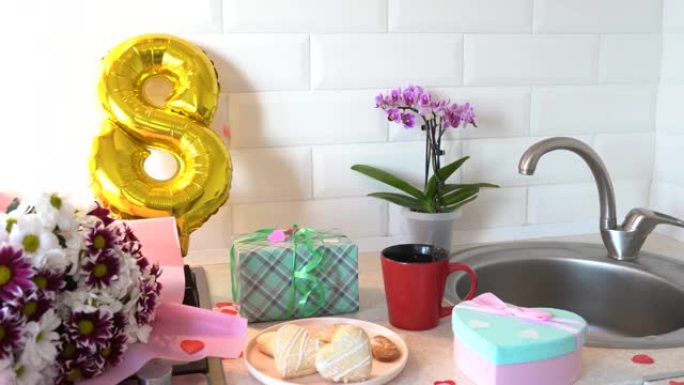 厨房里的五彩纸屑，配有金色气球、礼品盒和母亲节鲜花。3月8日国际妇女节