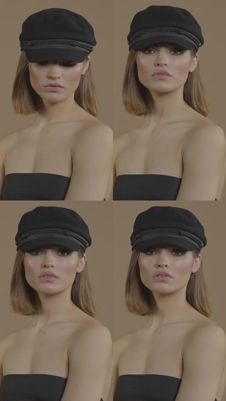一个漂亮的短发女孩，戴着黑色的帽子，画着黑色的眼妆看着镜头。垂直视频格式。