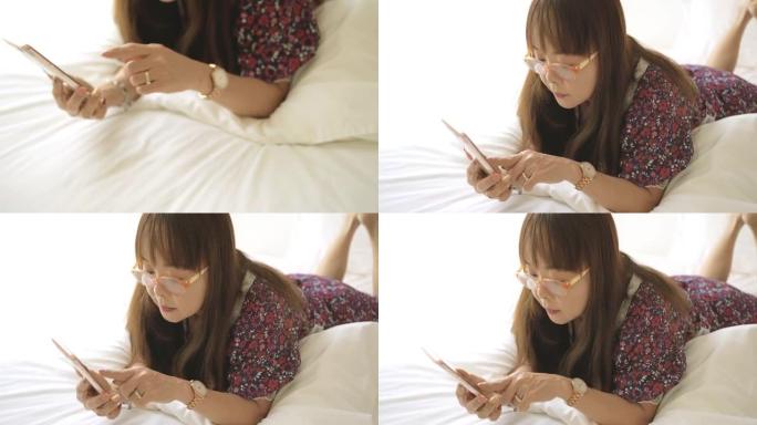 亚洲成熟女性在卧室里使用手机。