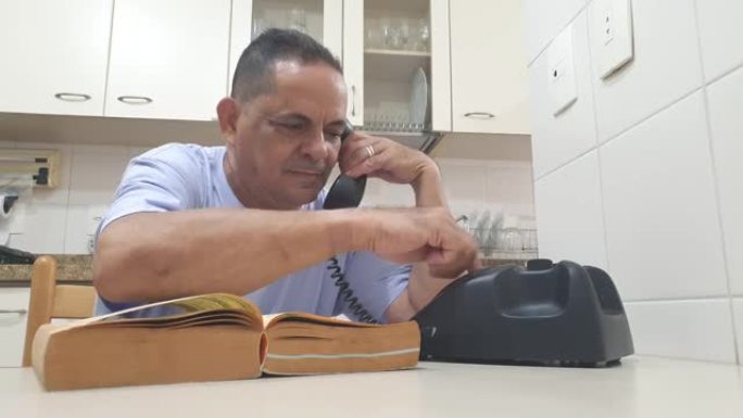 一个60岁的男人查了电话簿，然后打了电话