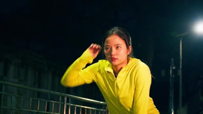 年轻的亚洲女跑步者晚上在城市进行激烈的跑步运动后筋疲力尽地休息。