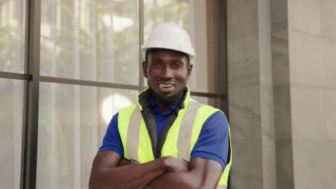 非洲裔美国工程师经理男子的脸部肖像，带着自信的微笑，双臂交叉，相信户外公司的服务质量