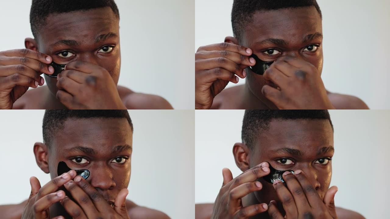 男子护肤非洲男子应用黑眼罩