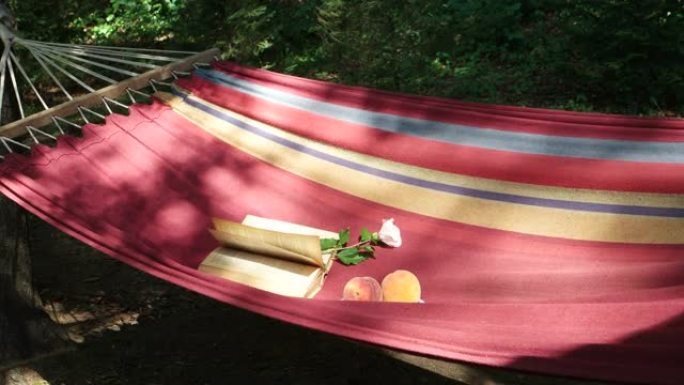 夏季花园树荫下的红色织物吊床