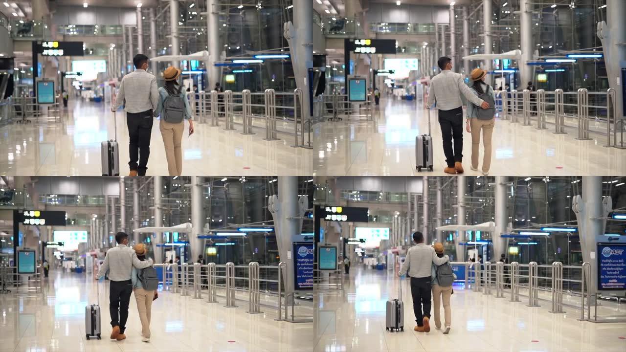 夫妇亚洲人走在机场航站楼等待登机。