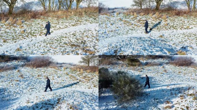 苏格兰西南部积雪覆盖的人行道上，一名高级男子独自行走的无人机的鸟瞰图