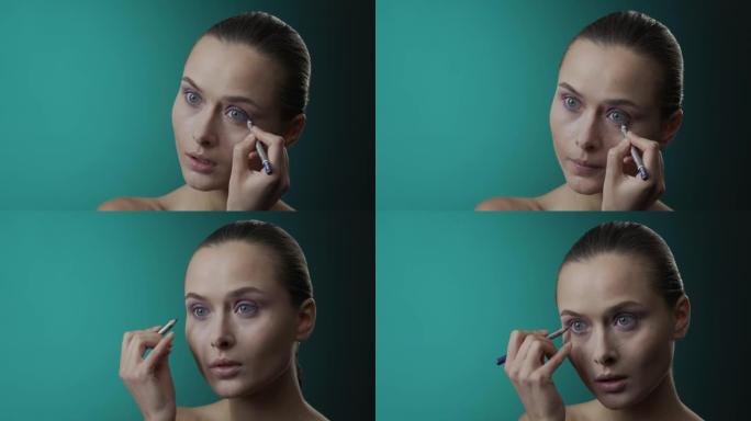 化妆申请的步骤。蓝眼睛的女孩用蓝色眼线笔在眼睛下部的粘膜上化妆。