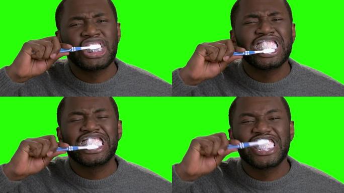 皮肤黝黑的男人刷牙。