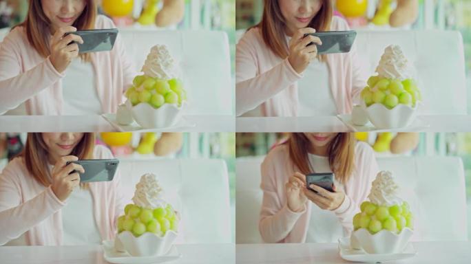 年轻女子在餐厅用智能手机拍摄冰苏的照片，并将照片上传到社交媒体