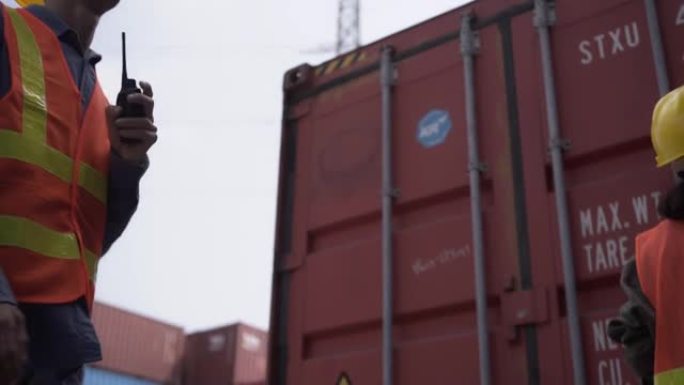 在集装箱码头工作的物流工程师和谈话检查货物货船的集装箱装载监控系统，以供进出口。