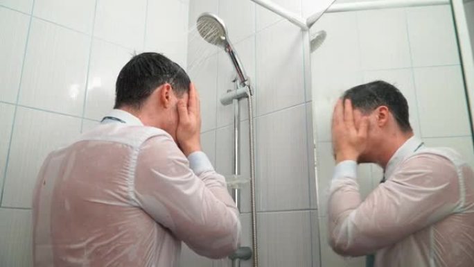 穿着衬衫和领带的悲伤男人站在浴室里淋浴，穿着衣服洗澡