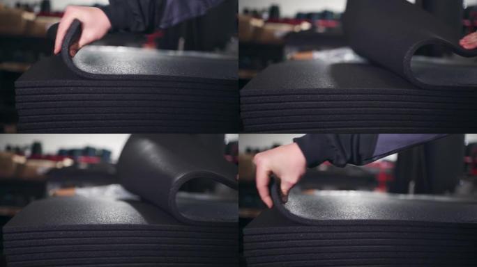 仓库工人的特写镜头检查准备交付的橡胶垫的灵活性