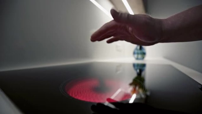 Man placing a hand above a glowing red hot plate o