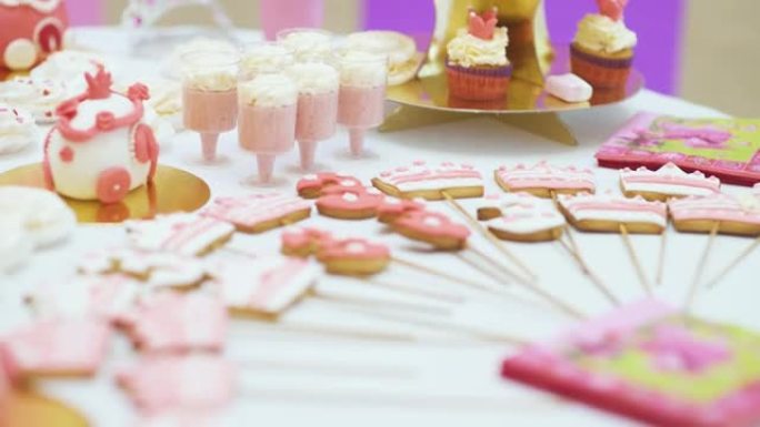自助餐，提供许多甜食，糖果棒站在白色桌子上，在庆祝活动中等待客人。漂亮的糖果棒，生日蛋糕和糖果