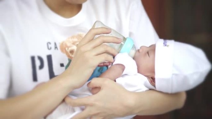 亚洲妈妈用奶瓶喂养婴儿