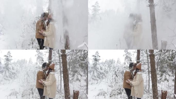 一对恋爱中的年轻夫妇站在树下拥抱，树上下了很多雪