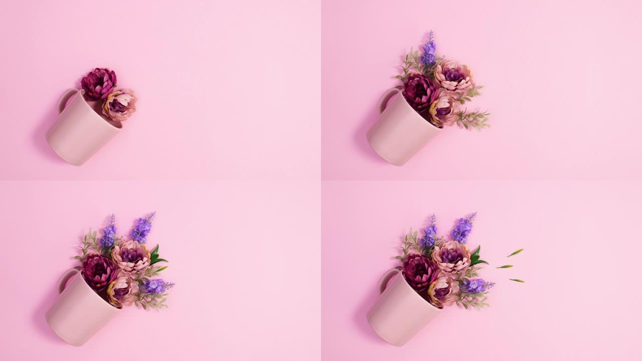 盛开的插花出现在明亮的粉红色背景上的粉红色杯子中。停止运动