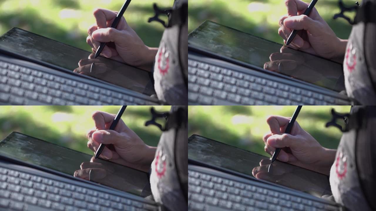 亚洲人在数字平板电脑显示屏上使用数字笔书写笔记。