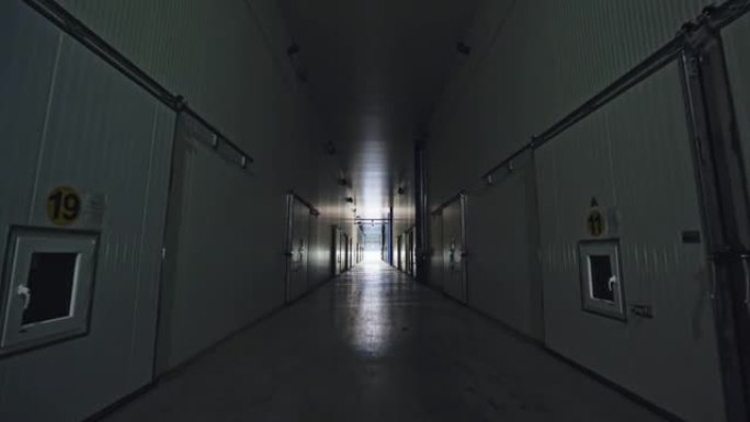 穿过昏暗的白色走廊，朝远处的明亮灯光走去，经过旁边的许多门