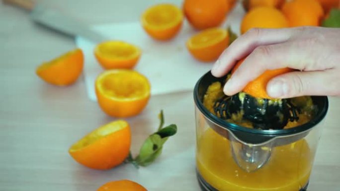 男子手榨汁榨汁机4k慢动作特写视频上的新鲜橙色水果。在家庭厨房准备柑橘汁饮料。挤压榨汁机。用于分离健
