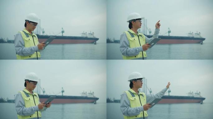 视频录像工程师在工业港口背景上检查手动移动触摸屏。