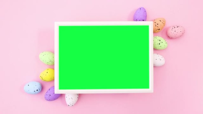 带有彩色鸡蛋的复活节绿色屏幕框架。停止运动