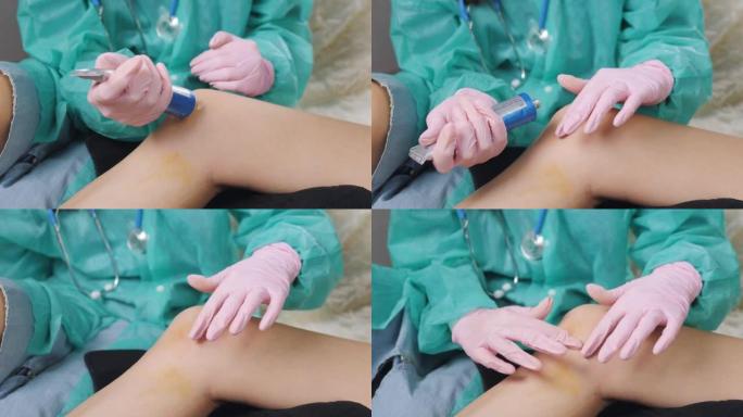一名戴着医用手套的护士在一名女性患者受伤的膝盖上摩擦药膏。