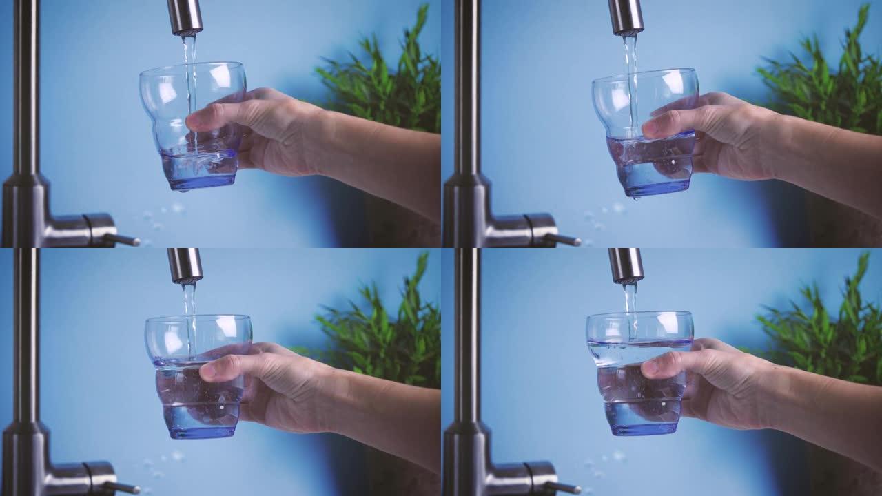 喝家用水。一个女人晚上在厨房用自来水装满玻璃杯。新鲜纯净的家庭用水，喝水是健康的生活方式。生态健康饮