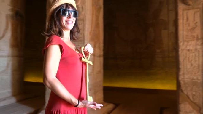 一个年轻的女人正在参观阿布辛贝神庙的内部装饰和珍贵的象形文字，在埃及南部的努比亚靠近纳赛尔湖。拉美西