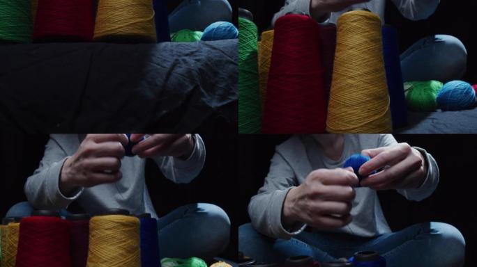 Female hands are winding yarn up to a ball