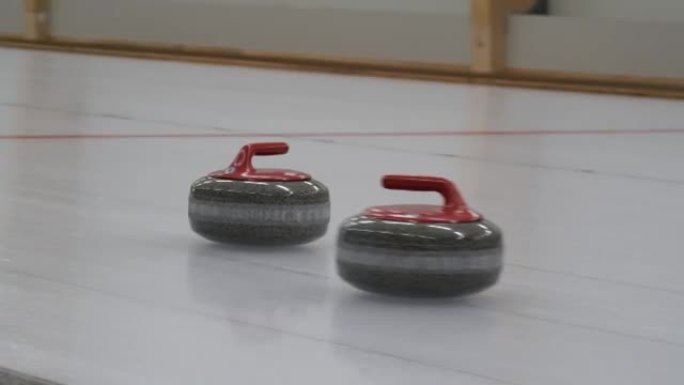 冰壶比赛。冰壶正在冰场上玩冰壶游戏。花岗岩石头在冰盖上滑动。