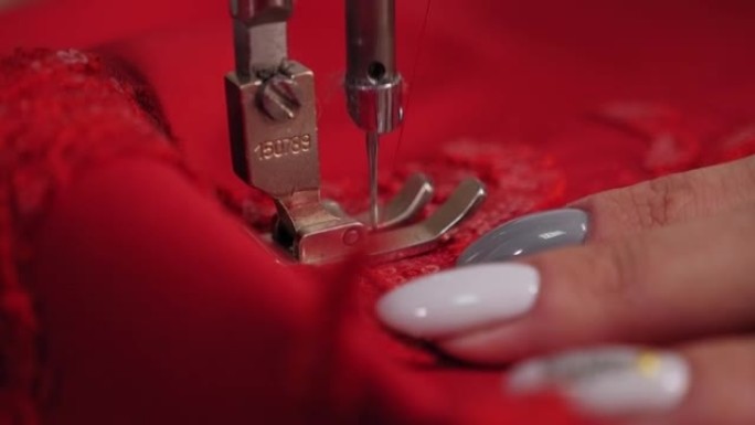 在专业工作室的缝纫机上缝制裁缝的特写镜头。
