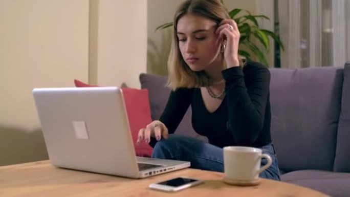 土耳其年轻女子在家工作或学习，桌上摆着电脑，端着咖啡杯