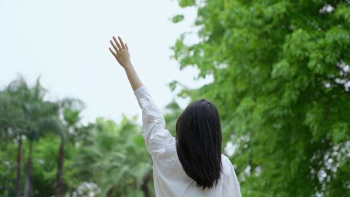 女孩向天空挥手清新自然美好