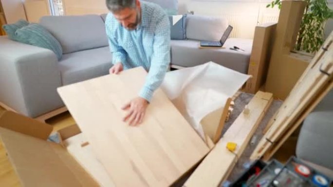 男子在家里打开装有新家具的纸板箱