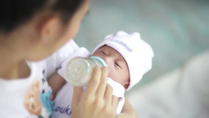 亚洲妈妈用奶瓶喂养婴儿