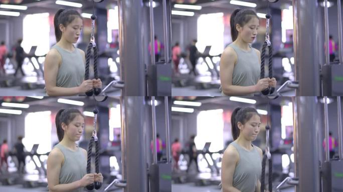 年轻的亚洲女性在健身房锻炼