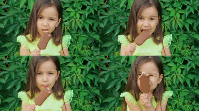 一个穿着鲜绿色连衣裙的可爱又有趣的小女孩做鬼脸，吃冰淇淋。