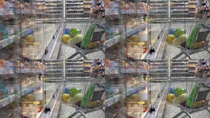 超市里一个看不见的幽灵打开了玻璃冰箱门。冰箱旁边有杂货的杂货车