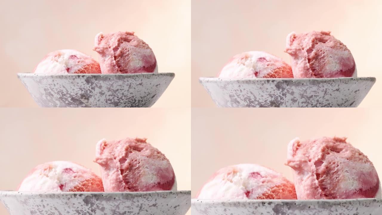 灰色陶瓷碗中两个粉红色草莓冰淇淋球的特写放大