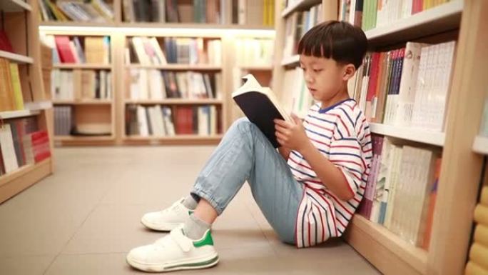 快乐的亚洲孩子在图书馆读书。