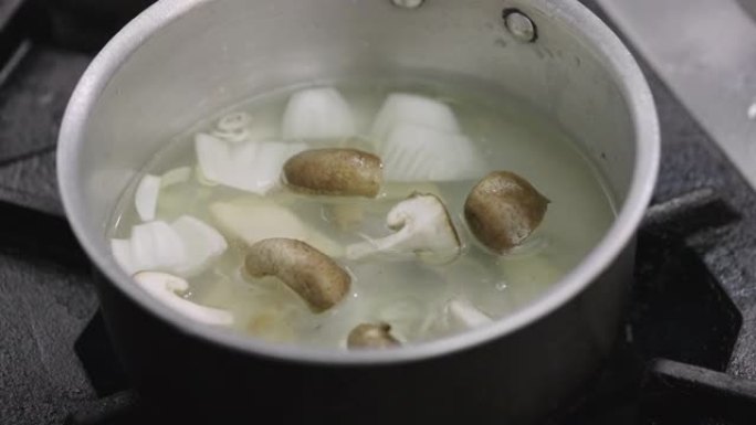 SLO MO: 家庭厨师将牡蛎蘑菇放入沸腾的汤中。