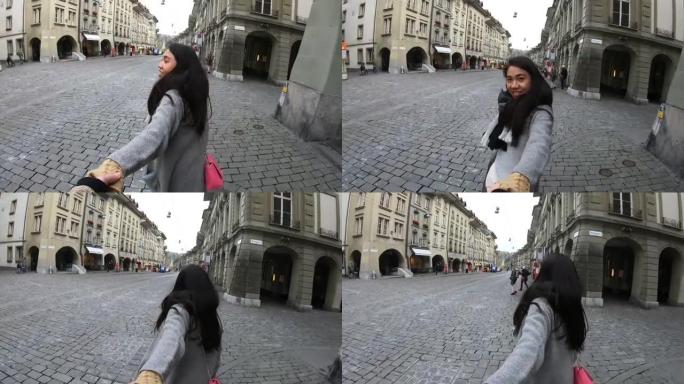 男人牵着女人的手在老城区散步的观点