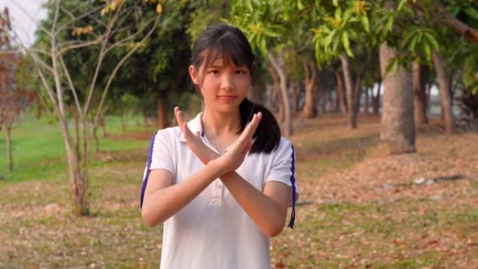 运动的亚洲年轻女子的面部表情，拟人化的笑脸，拒绝手势